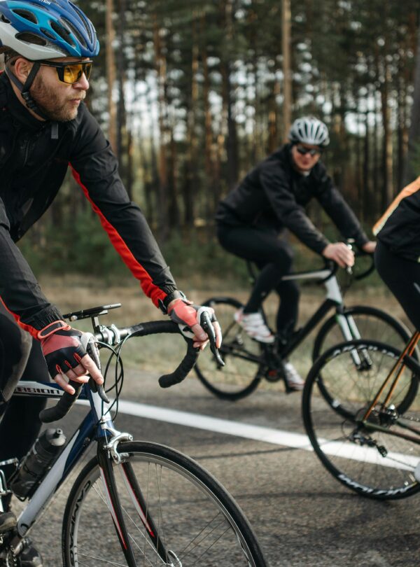 Group of cyclists on a scenic outdoor road, showcasing speed and athleticism.