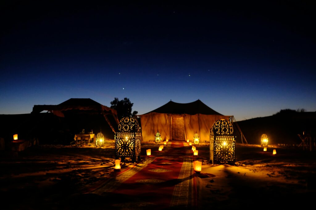 Illuminated tents with lanterns at twilight in Egypt's desert, creating a magical ambiance.