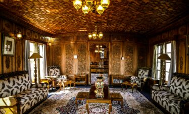 Ornate room with wooden decor, lighting, and elegant furniture creating a luxurious ambiance.